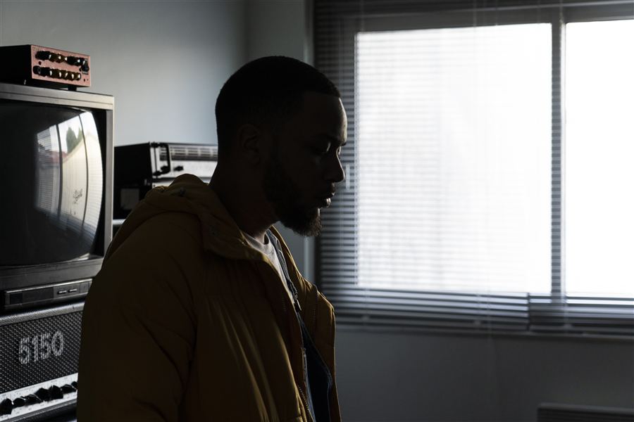 Profil d'un homme en veste jaune face à la fenêtre
