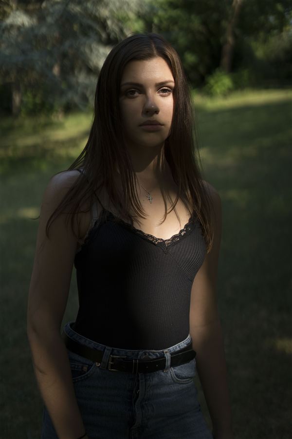 Portrait vertical d'une femme dans la lumière du sous-bois