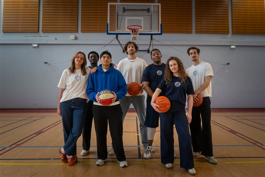 Équipe de basket réunie devant un panier