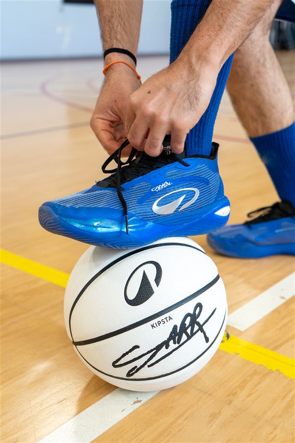 Chaussures bleues et ballon blanc sur le parquet