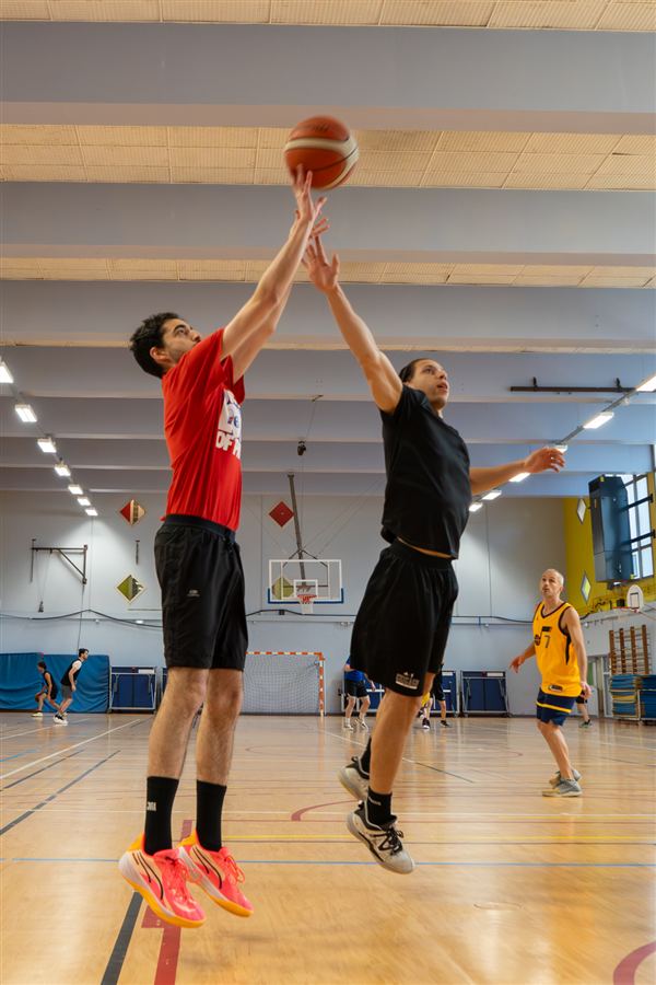 Deux joueurs de basket disputent un ballon en hauteur