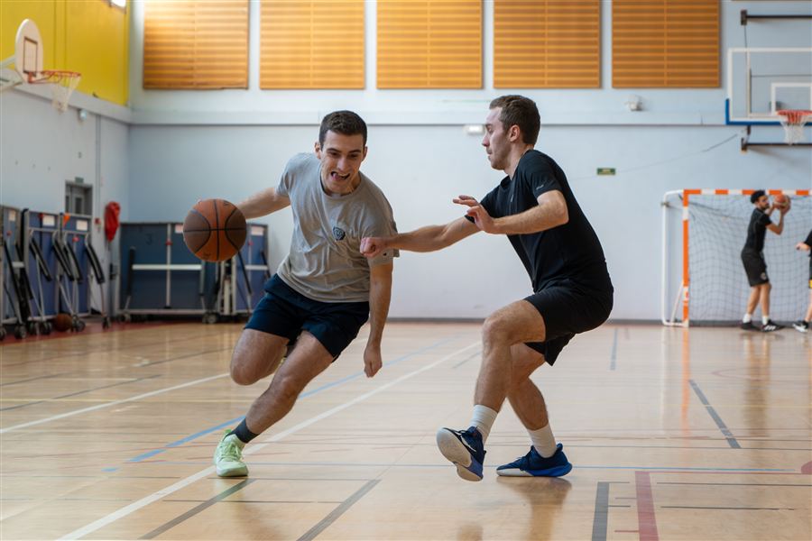 Joueur de basket débordant son adversaire sur le parquet