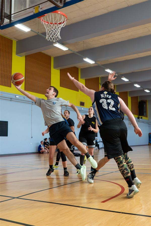 Joueurs de basket en mouvement sous le panier